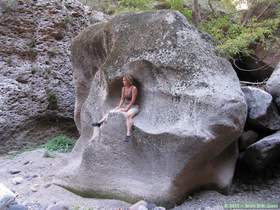 Mindy sitting on a flood scoured boulder in Virgus Canyon