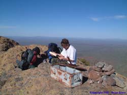 Jeff writing in the trail register at the top of Mt. Ajo