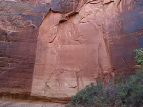 Color change in the wall where a slab of sandstone with desert varnish has cleaved off revealing the lighter, unaltered sandstone behind.