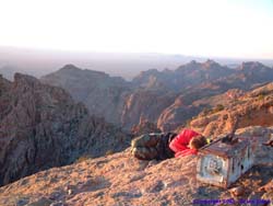 Jeff huddles up for warmth in the cool evening air at the top of Mt. Ajo waiting for the sun to set.